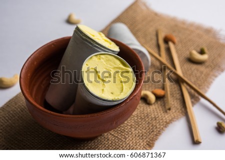 Rajasthani Shahi Kulfi is a popular frozen dairy dessert and known as Indian Ice Cream, Saffron flavoured with dry fruits. Served in a plate with Aluminium Moulds and Bamboo sticks, selective focus