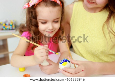 Happy easter. A mother and her daughter painting Easter eggs. Happy family preparing for Easter. Cute little child girl wearing bunny ears on Easter day.