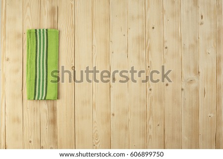 Wooden picnic table with green dishcloth on.