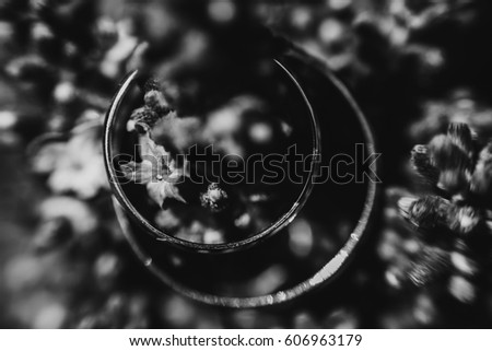 Black and white picture of wedding rings lying on the flowers