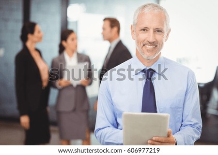 Portrait of businessman with digital tablet in office