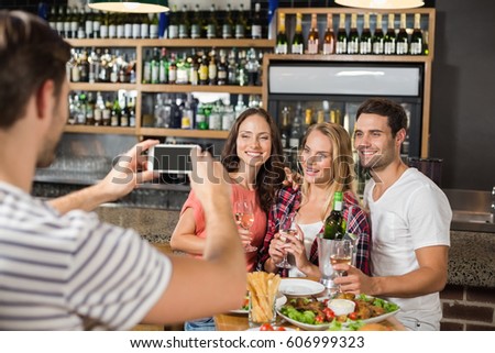 Man taking picture of friends in a bar