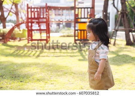 A cute happy little girl asian playing bubble in the garden.