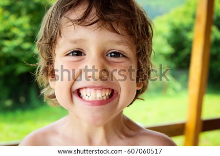 Happy kid smiling and laughing outdoors. Cute little baby boy having fun outside. Royalty-Free Stock Photo #607060517