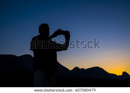 Man silhouette in the mountains with a smartophone in Basque Country Spain
