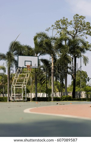 Basketball court in tree and sky background, 