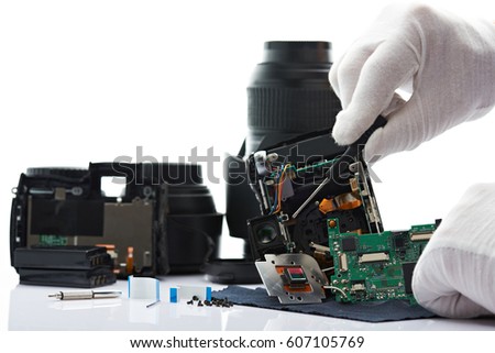 Disassemble modern photo digital camera isolated on white background. Man fixing photo camera