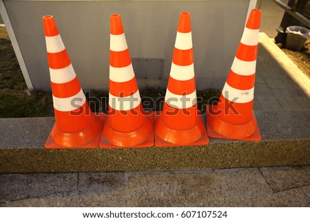 Plastic striped orange road sign in the form of a cone