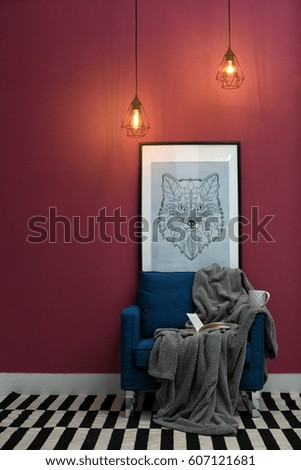 New blue armchair with blanket and book in modern room