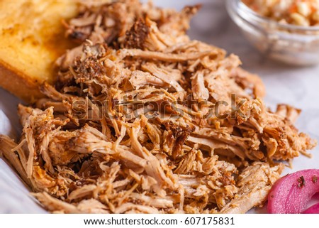 Close up shot of pulled pork fibers in a sandwich freshy served on a platter Royalty-Free Stock Photo #607175831