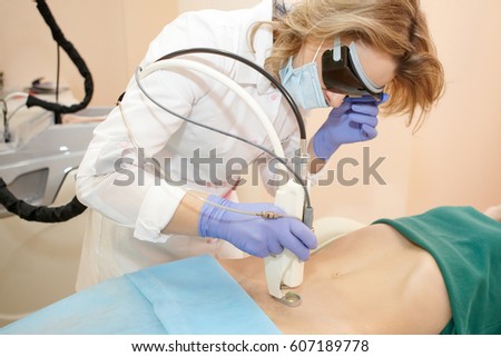 Hair removal cosmetology procedure from a therapist at cosmetic beauty spa clinic. Laser epilation and cosmetology. Royalty-Free Stock Photo #607189778