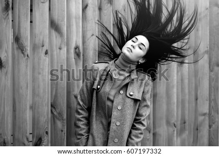 Young brunette woman outdoor with blowing up hair