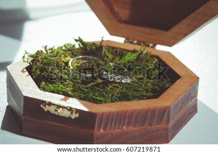 Wedding rings on green moss. Rustic wedding. Vintage filtered picture style.