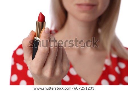 Woman holding red lipstick in her hand. Beauty and fashion concept