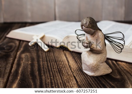 an angel cross and bible on wooden background Royalty-Free Stock Photo #607257251