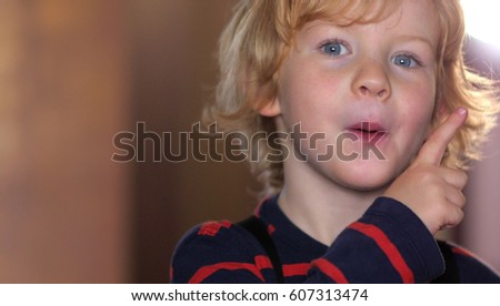 Happy Face Of A Little Blonde Boy
Portrait of a little boy while showing the index finger upwards 