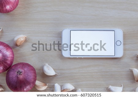 White screen smartphone on kitchen wooden table.