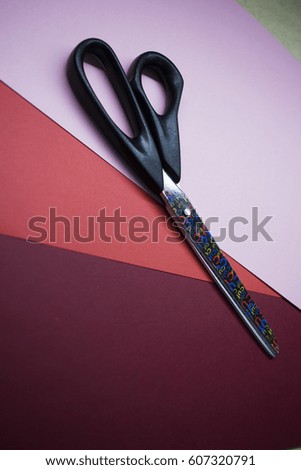 big black scissors on red and pink paper