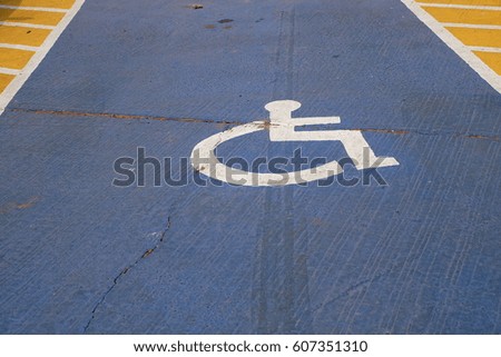 disabled parking sign painted on tarmac