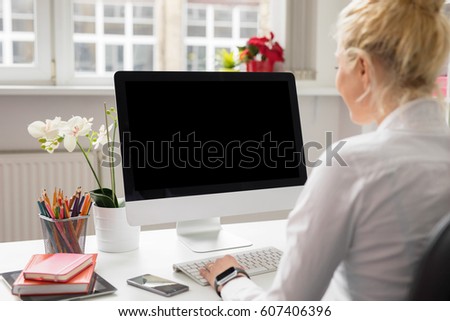 Woman in office working on stationary computer Royalty-Free Stock Photo #607406396