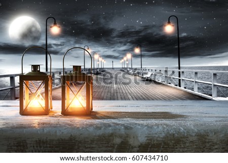 Wooden desk of free space and pier with sea at night time 
