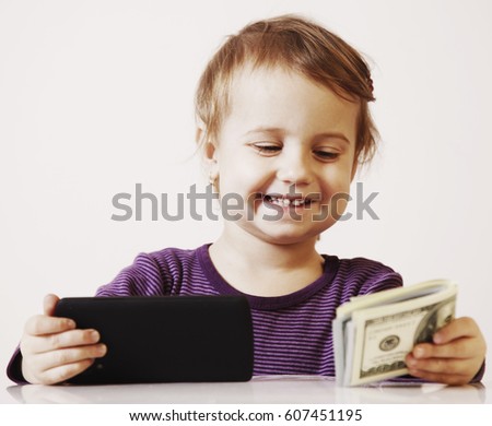 Very happy business baby girl with smart phone and dollar banknotes celebrating good news. Success, wealth management concept. (Humorous picture)