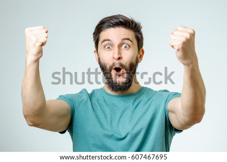 Young man and sign of victory isolated on gray background