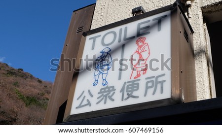 Toilet sign in Japanese and English with drawing of gent and lady in old fashioned traditional clothing