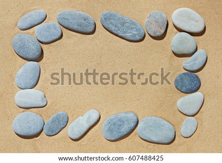 Frame with blank space made of colorful beautiful natural Shingle on yellow sand background on sea side shore