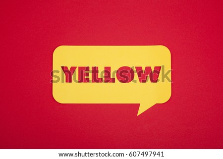The yellow word cut in the cardboard bubble on a red paper background from above. 