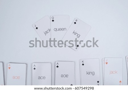 Poker royal flush of spades playing cards balanced on white background.