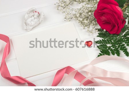 Mockup. Postcards and flower composition with scarlet rose and fern on white table.