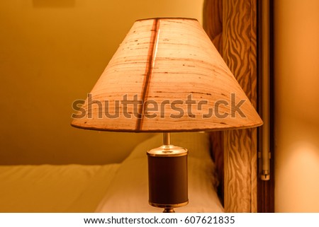 Table lamp shade glowing with a blurry background.