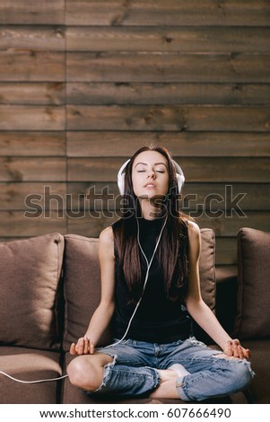 Beautiful woman listening music and meditates Royalty-Free Stock Photo #607666490