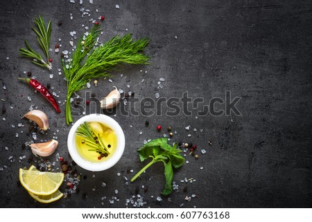 Selection of spices herbs and greens. Ingredients for cooking. Food background on black slate table. Top view copy space.