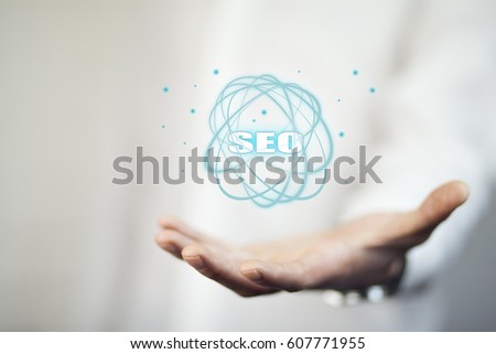 Business man holding SEO text on screen