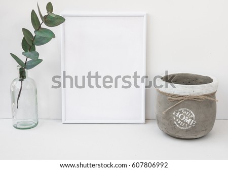 White frame mockup, eucalyptus branch in glass bottle, cement bowl, styled minimalist clean image for product marketing, social media, blogging