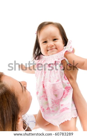 Woman holding up a baby in her arms .