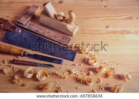 Carpentry tool concept, vintage equipment for working with wood. planer, saw and chisel on wooden table with shavings Royalty-Free Stock Photo #607858634