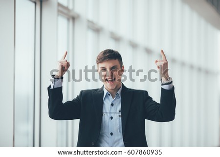 Portrait of a young business man pointing finger up isolated on the white background