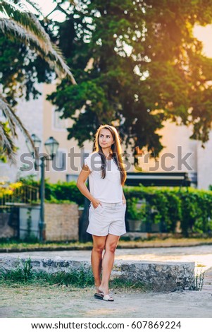 Young beautiful girl on the old historic street at sunrise in old town of Budva in Montenegro