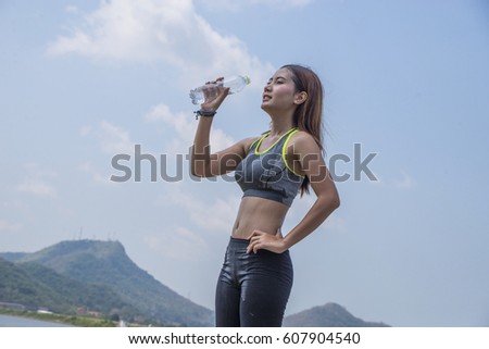 woman thirsty and drinking pure water after jogging or exercise healthily concept