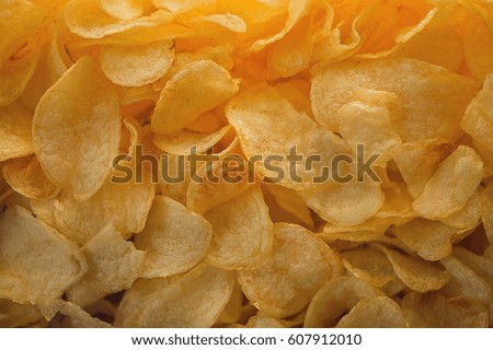A lot of potatoes chips. Yellow salted potato chips as background. Chips texture.
