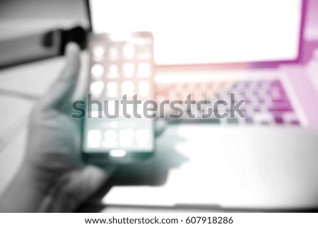 Picture blurred  for background abstract of hands using smart phone connecting to laptop