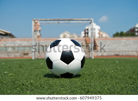 Soccer ball in front of the goal door.
