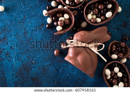 Delicious chocolate easter eggs ,bunny and sweets on dark blue background,easter concept background