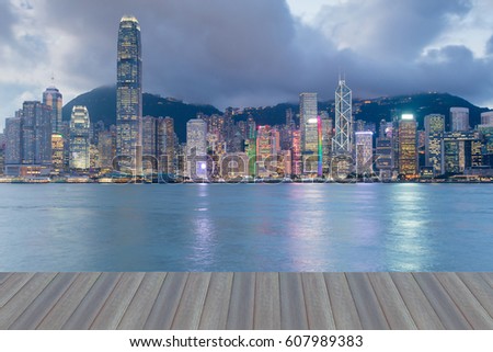 Opening wooden floor, Hong kong office building at twilight sea front, cityscape background