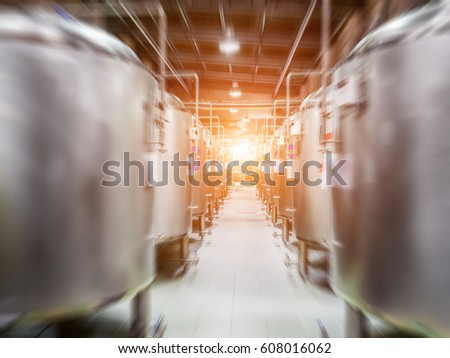Modern Beer Factory. Steel tanks for beer fermentation and storage. Motion blur effect, sunlight