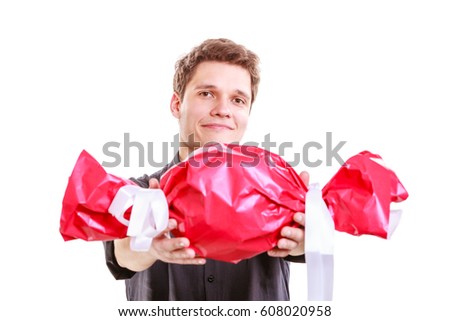 Helping and sharing concept. Young brunet man with big red sweet candy. Celebration and anniversary time. Isolated on white.