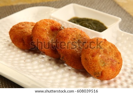 golden fried crisp cutlets served with green mint chutney Royalty-Free Stock Photo #608039516